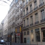 Investissement à Lyon dans une rue avec des immeubles et ligne de bus